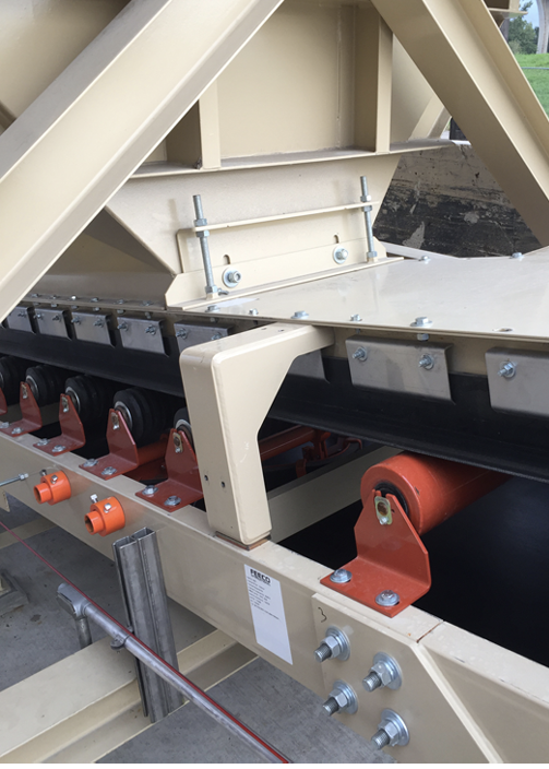 A belt feeder over a conveyor with impact idlers and skirt boards. Photo: FEECO International